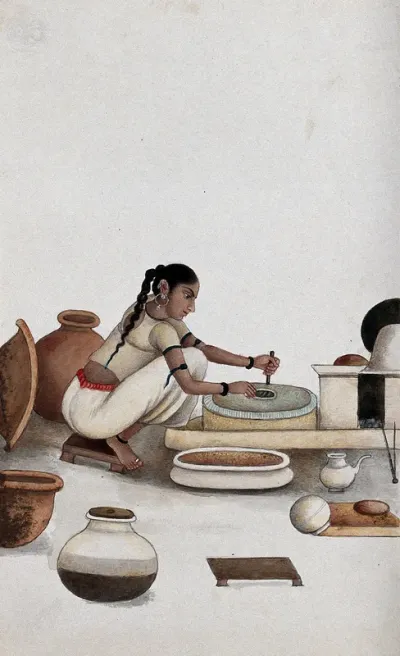 Delhi: a woman grinding grain into flour