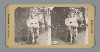 Een man houdt een vrouw op een fiets in evenwicht