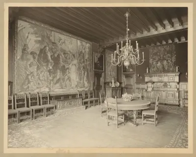 Eetkamer met wandkleden aan de muur