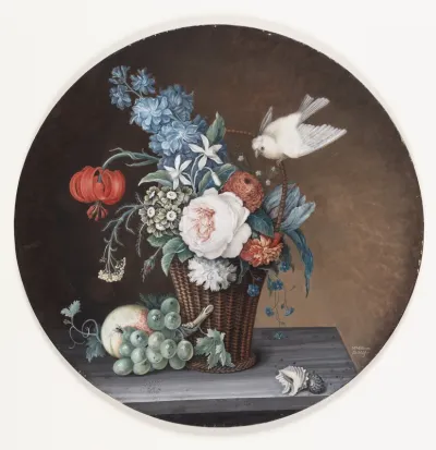 En kurv med blomster på et bord; ved siden af kurven en klase vindruer og en fersken; paa kurvens hank sidder en kanariefugl.