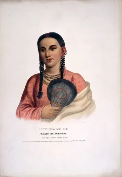 Female Flying Pigeon, a native American woman with plaits, wearing a pink dress with flower decor and shawl, necklaces and holding a feather fan