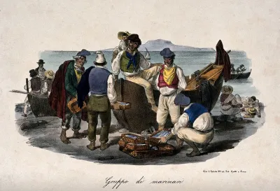 Fisherman are on the sea shore with the boat from which they have unloaded their catch and they are selling the fish to other traders
