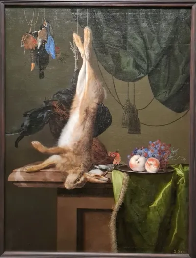 Fruits of the hunt: Hare and poultry above a plinth with blue curtain and dish of fruit on a green tablecloth