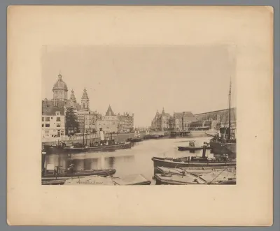 Gezicht op het Centraal Station, het IJ, de Sint-Nicolaaskerk en de Montelbaanstoren te Amsterdam
