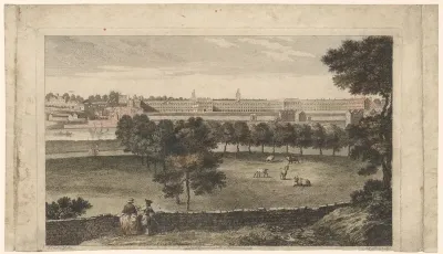 Gezicht op weide en gebouwen aan overkant van een rivier