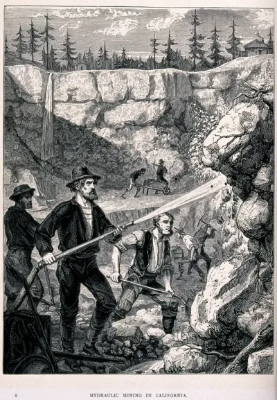 Gold mining: a man using a hose to wash away soil