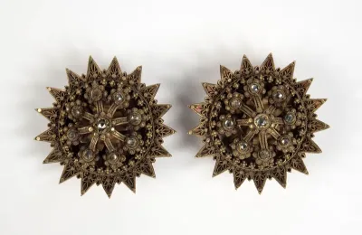 Golden earring inlaid with stones