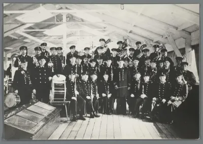 Groepsportret van een onbekende groep mariniers met muziekinstrumenten op een schip