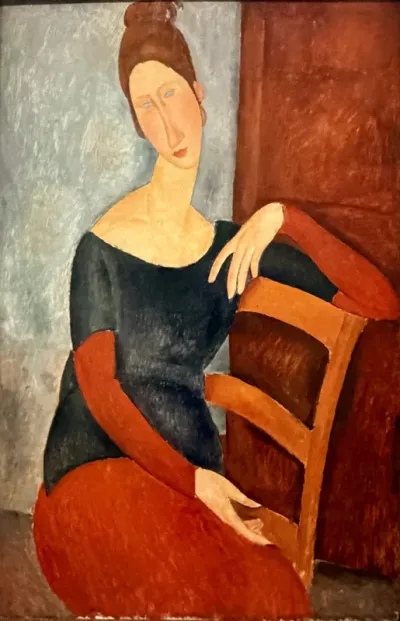 Jeanne seated with the arm resting on the back of the chair