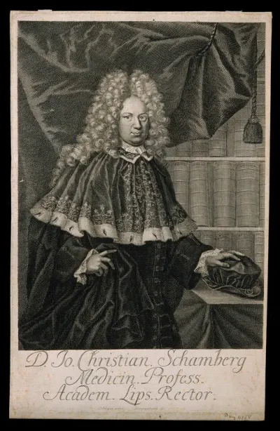 Johann Christian Schamberg, standing in front of a bookcase