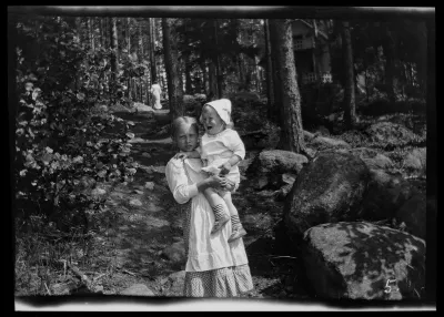Lastenhoitaja ja Tom Simberg Selkärannan ateljeen laiturille johtavalla polulla, taustalla todennäköisesti Anni Simberg
