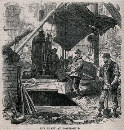 Men hauling excavated soil up a shaft in a bucket suspended from a rope, driven by a steam hoist