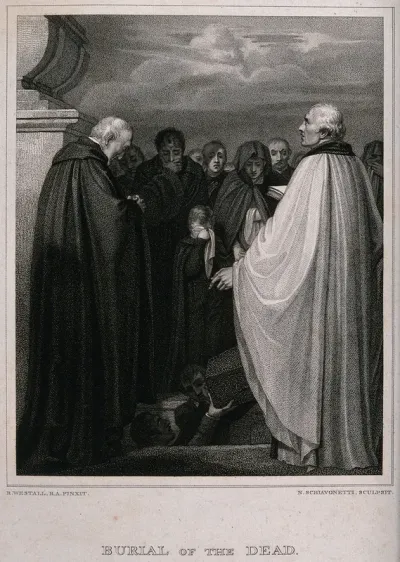 Mourners attending a burial where the coffin is about to be lowered into the ground