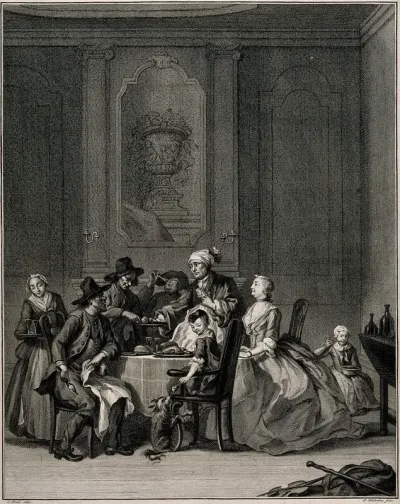 People having a meal with a woman presiding over the table