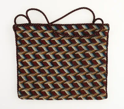 Plat tasje met geborduurd zigzag-motief in rood, zwart, wit, bruin en blauw