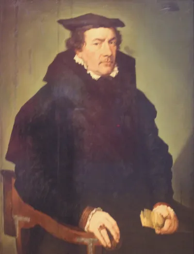 Portret of a sitting man holding a pair of gloves