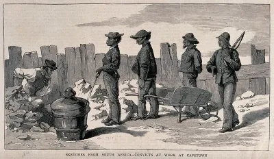 Prisoners in Cape Town with spades and a wheelbarrow are digging a hole in the road: a guard with a rifle stands by