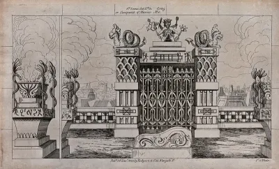 Scenery to be used in a toy theatre: a large gateway between two decorated pillars surmounted by dragons set overlooking a town