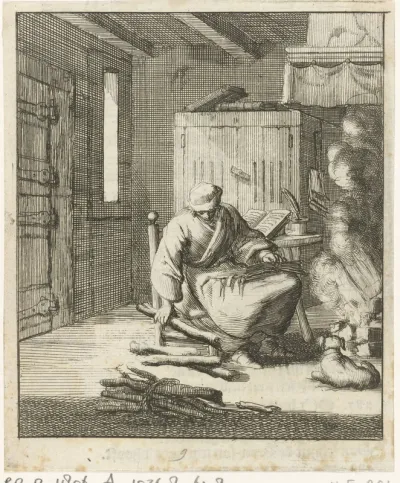 Schrijver Willem Sluiter zit op een lage stoel bij het vuur en raapt een paar stukken brandhout op