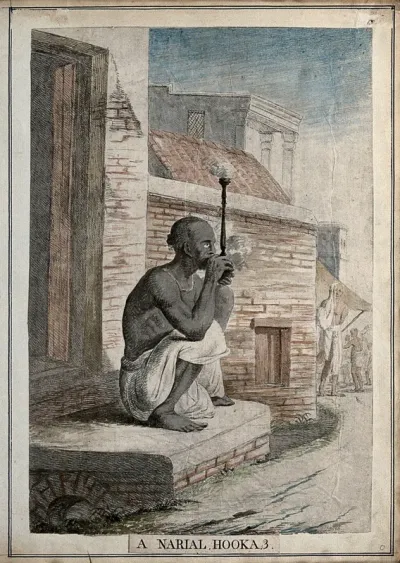 Seated man in doorway smoking a cocoa nut hookah, Calcutta, West Bengal