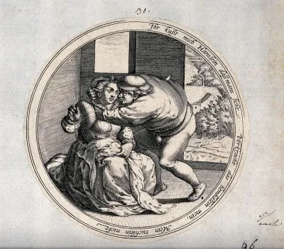 The man reaches forward to kiss the woman