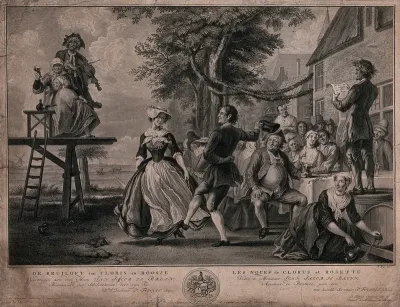 The wedding of Kloris and Roosje: a couple dance to the music of a fiddler, other people sit at a table eating and drinking