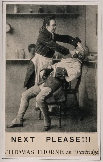 Thomas Thorne in character as a barber shaving a man