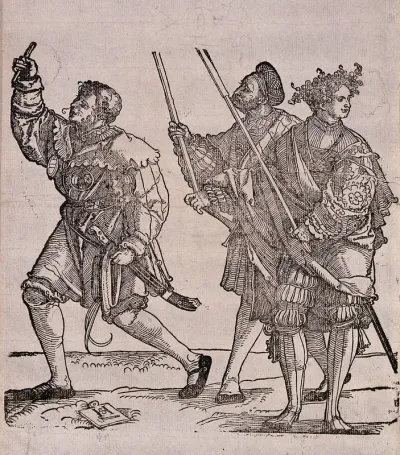 Three men in costume with staffs in their hands