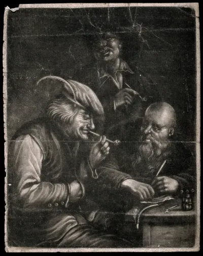 Three men sit and stand by a table to smoke