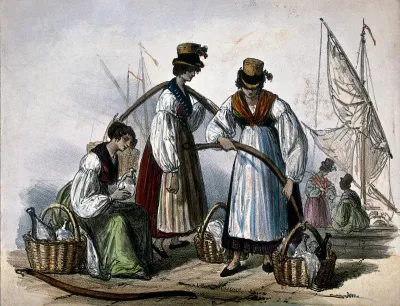 Three young women are on a quayside arranging the baskets and bottles from which they sell drinks
