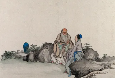 Two Chinese artist men have a discussion on some rocks in a garden