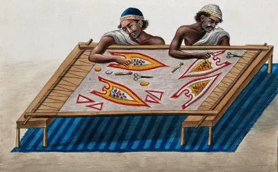 Two men doing embroidery on a piece of cloth