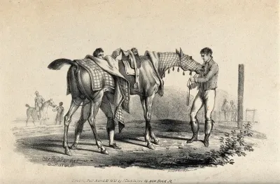 Two men grooming and getting a race horse ready on a race course