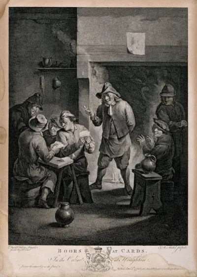 Two men play cards at a table as others watch and smoke by the fire