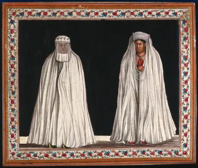 Two Muslim women wearing white burkas, one with her face covered with a veil