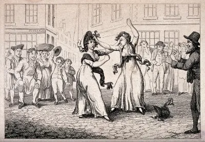 Two women are fighting in the street as acrowd cheers them on