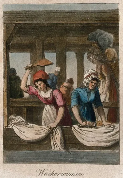 Two women are washing and beating sheets in a wash house