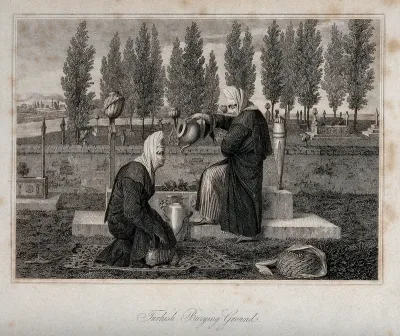 Two women in a Turkish burying ground; one kneeling on a rug, the other watering plants