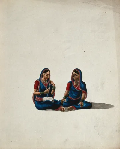 Two women in blue and red sarees sitting together