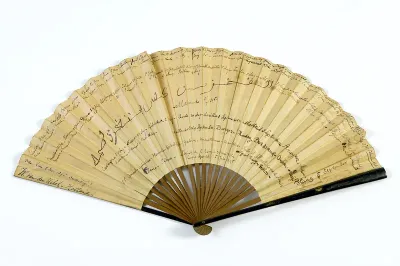 Vouwwaaier, montuur van hout, buitenbenen zwart gelakt, waaierblad van papier, één zijde bedrukt met vogels en bloemtakken, andere zijde in inkt handschrift met reisdata en plaatsen