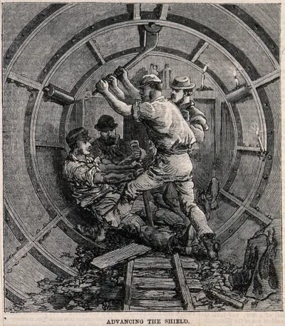 Workmen fitting the metal casings for an underground tunnel