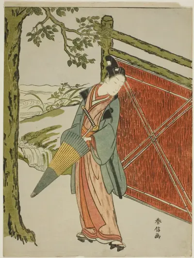 Young Man Holding Umbrella Beside a Fence