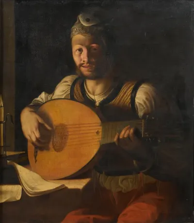 Young man playing a lute by candlelight