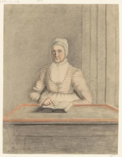 Zittende vrouw aan een tafel met open