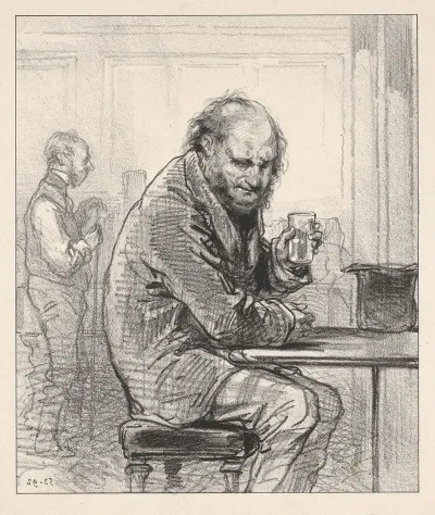 Man Seated At Table Holding Drink