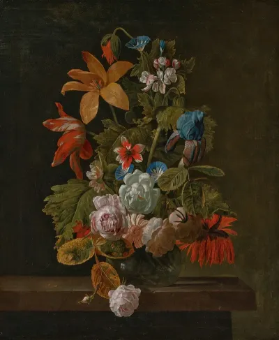 Tulips Roses An Iris And Various Flowers In A Glass Vase On A Stone Ledge